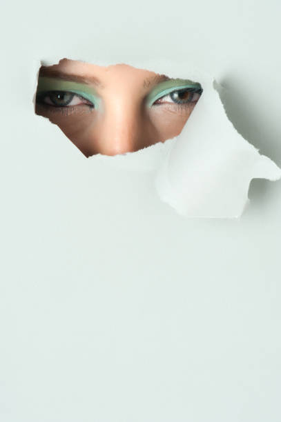 istock Young woman looking out through hole 154888630