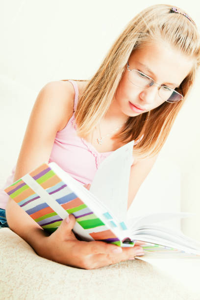 istock Young girl reading a book 154890180