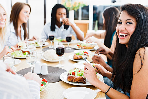 istock Happy young friends or colleagues gathered round dining table 154890241