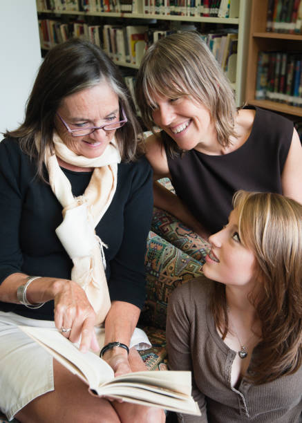 istock Three generations women reading in a public library, vertical. 154891064