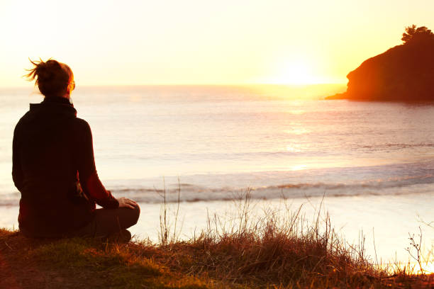 istock Woman meditating on cliff over ocean 154891107