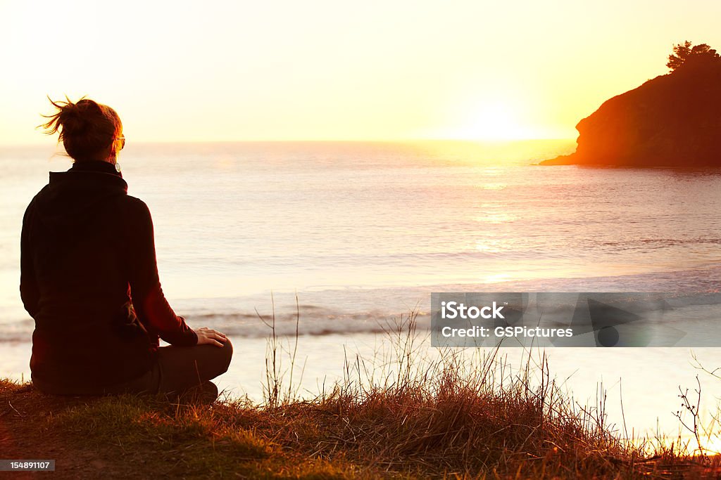 Женщины, Медитировать на скале с видом на океан - Стоковые фото Женщины роялти-фри