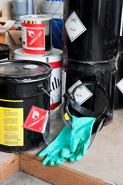 Five piled buckets containing flammable liquids Piled buckets and cans of hazardous chemicals along with the face shield and gloves to handle them. Skull and cross bones symbol and flammable liquids. drum container stock pictures, royalty-free photos & images