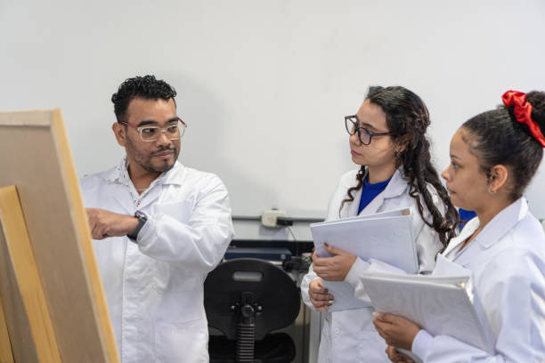 istock Researcher on a board explaining to her lab partners 1548912874