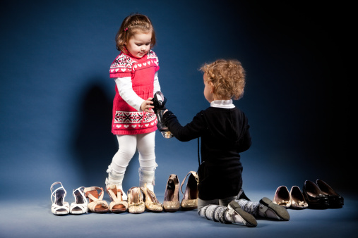 Two young ladies with shoes. Studio shot