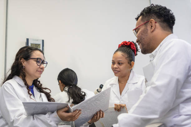 istock Group of colleagues sitting and discussing a project while working together in a laboratory. 1548914989