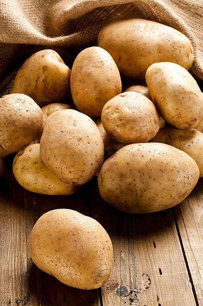 raw de pommes de terre dans un panier sur la table en bois rustique - raw potato organic rustic bag photos et images de collection