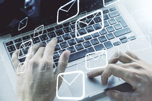 istock Creative concept of postal envelopes illustration with hands typing on laptop on background. Email and communications concept. Multiexposure 1548932199