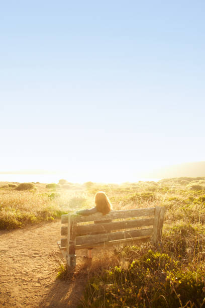 istock Woman sitting on bench in nature 154894199