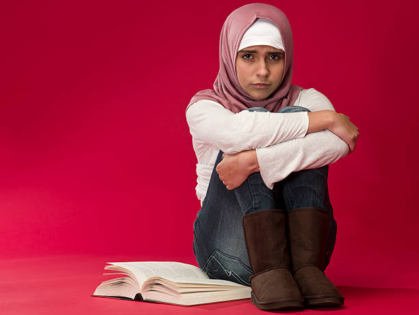 close-up moslem woman reading a book isolated on white