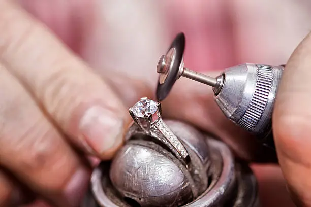 Jeweler polishing the diamond ring. 