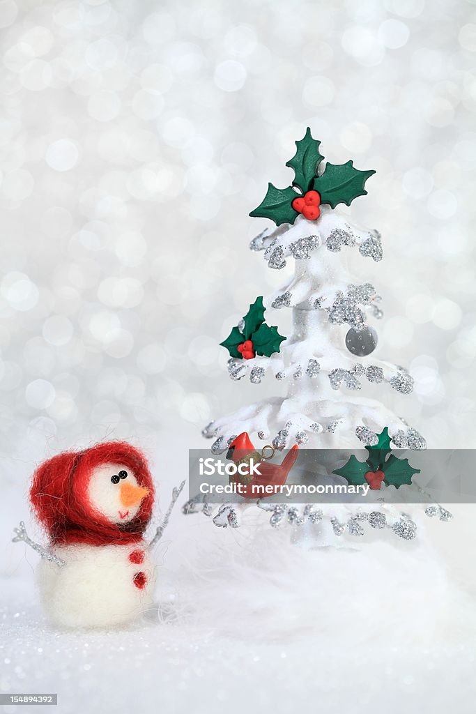 Snowgirl and Christmas tree XXXL photo – macro of a cute little girl snowman with a red hood who is surprised to see a red cardinal on her Christmas Tree.  Short depth of field with focus on her eyes to create the blurry sparkle snowy background.  Snowgirl made entirely from scratch by the photographer. very retro 1970’s stop motion animation styled image. Female Animal Stock Photo