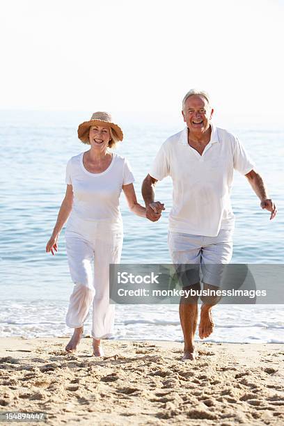 Senior Couple Enjoying Beach Holiday Stock Photo - Download Image Now - 60-69 Years, 70-79 Years, Active Lifestyle