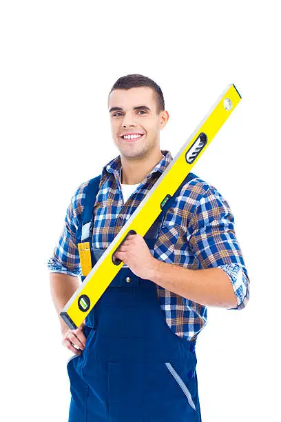 Portrait of happy carpenter with typical spirit level. Looking at camera and smiling. Studio shot on the white background.