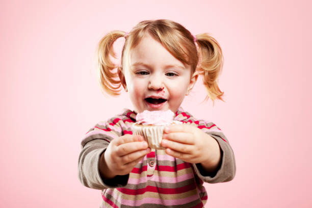 a little boy wanting a cupcake.Focus is a little soft.