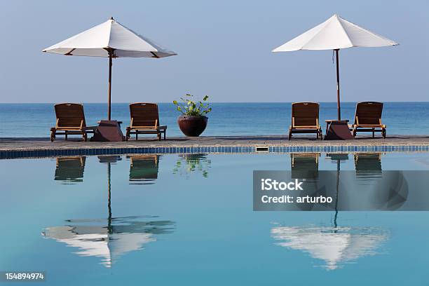 Sunchairs Y Sombrillas De La Piscina Foto de stock y más banco de imágenes de Agua - Agua, Aire libre, Arena