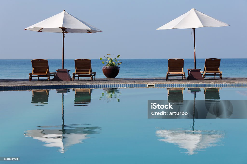 sunchairs e guarda-sóis ao lado da piscina - Foto de stock de Areia royalty-free