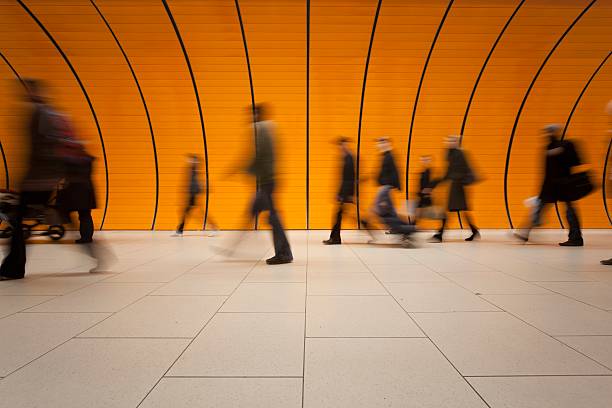 grupo grande de personas y moderno naranja tubo de metro - architecture blurred motion city lighting equipment fotografías e imágenes de stock