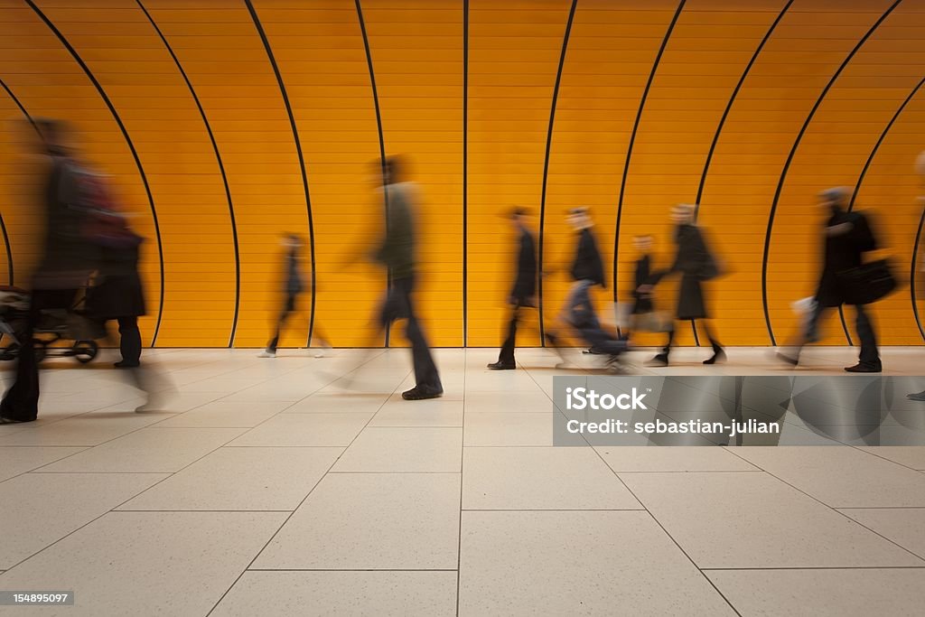 large group of people against modern orange subway tube  Long Exposure Stock Photo