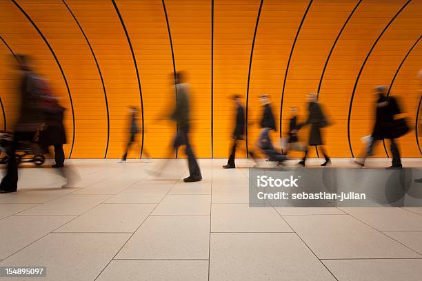 Large Group Of People Against Modern Orange Subway Tube Stock Photo - Download Image Now
