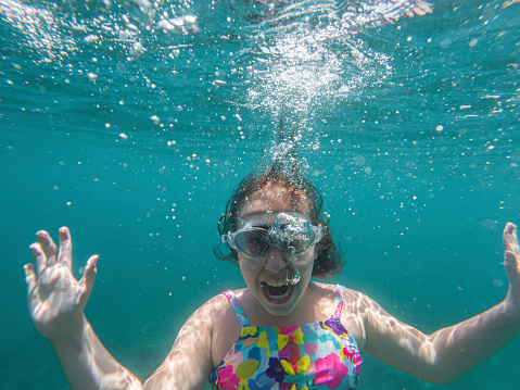 Portrait of a crazy teenage girl shouting underwater