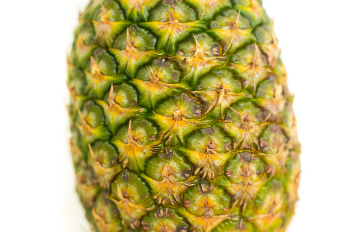Ripe pineapple fruit cut in a triangle shape on rustic wooden table for high fiber fruits concept.