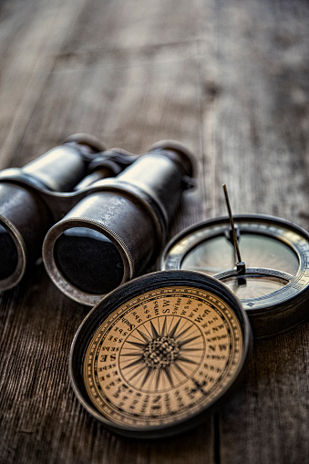 This is a close up photograph of a Antique Compasses on Old Wood