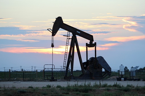 Colorful sunset behind pump jack in West Texas
