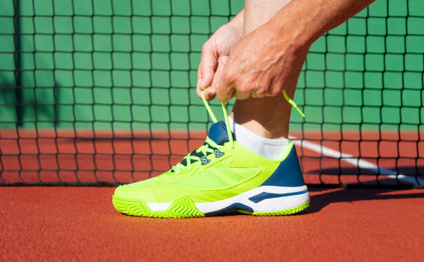 männliche hände binden schnürsenkel von padelschuhen auf dem platz. - tournament bracket fotos stock-fotos und bilder