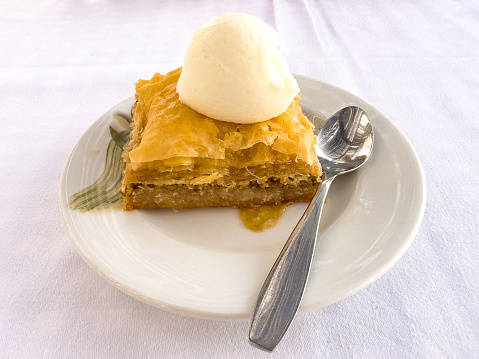 A serving of Greek baklava with a scoop of vanilla ice cream