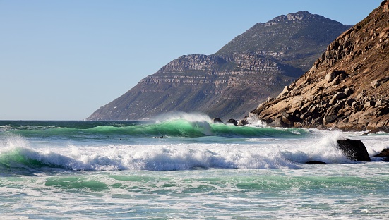 Noordhoek beach in South Africa's picturesque Cape Town, surrounded by lush green mountainous terrain