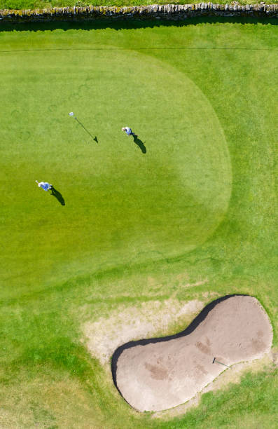 istock Golf course green aerial view and two players 1549023867