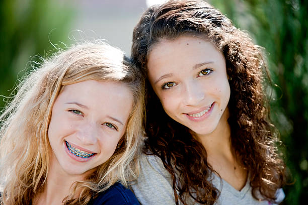 vraies personnes: tête épaules souriant caucasiennes adolescentes sisters lits jumeaux - people child twin smiling photos et images de collection