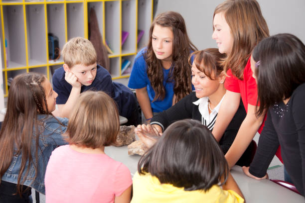 istock Group of elementary age children talking with their teacher 154905632