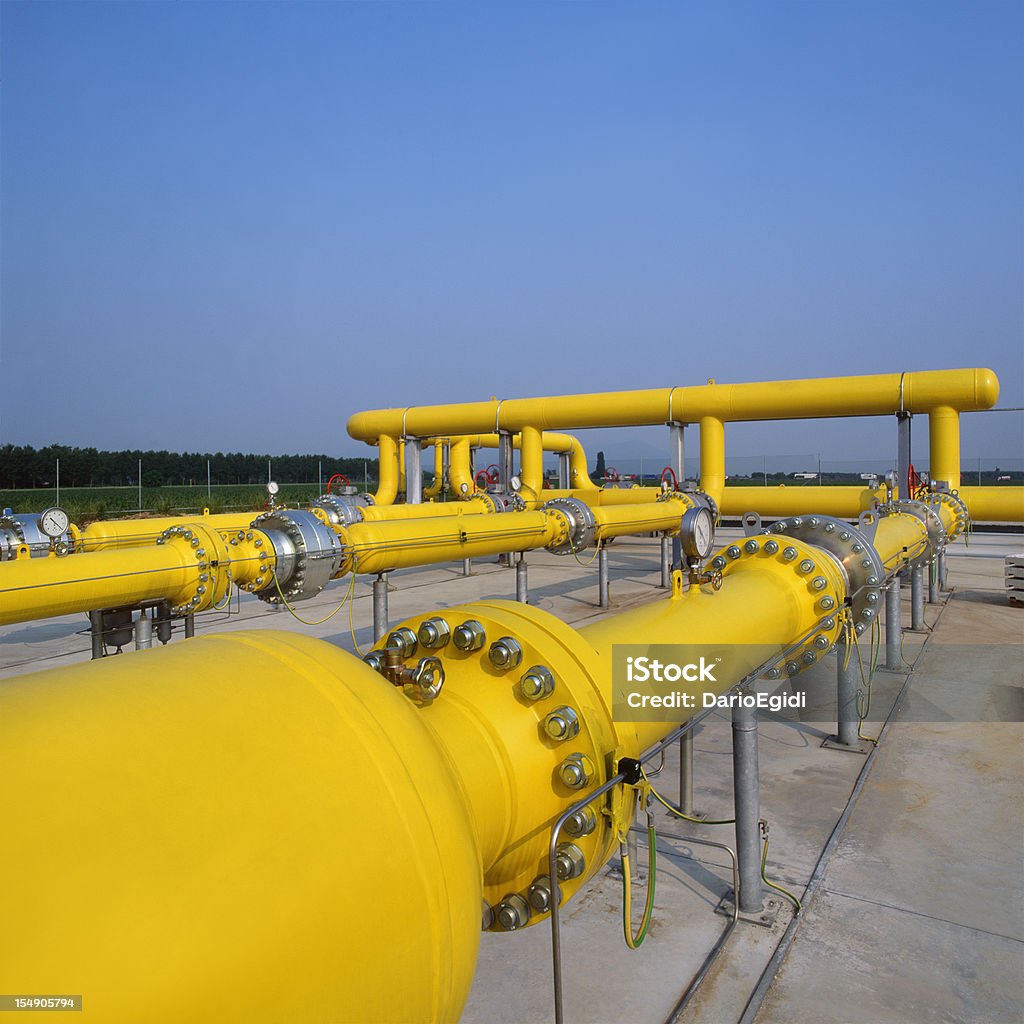 Tubi gas giallo nella stazione di distribuzione, cielo blu sullo sfondo - Foto stock royalty-free di Giallo