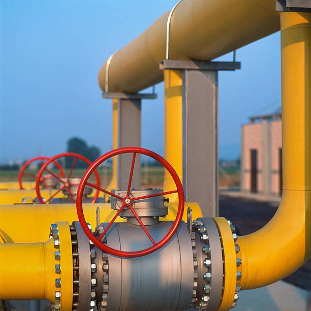 Red valve on yellow pipes in natural gas distribution station stock photo