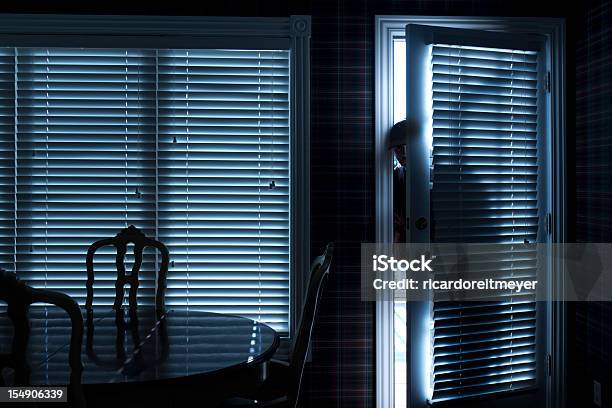 Burglar Breaking In To Home At Night Through Back Door Stock Photo - Download Image Now