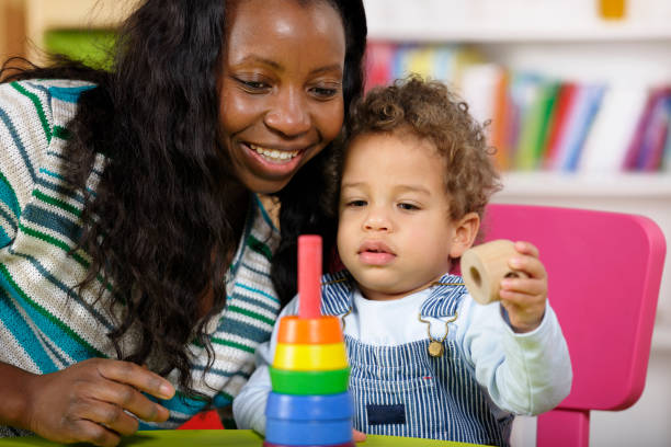 Toddler And Carer Playing With Multi-coloured Rings