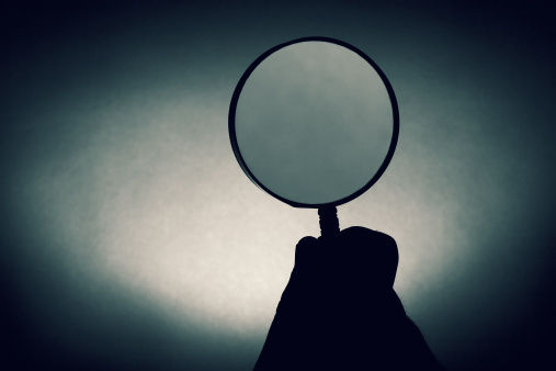 a magnifying glass silhouette back lit.