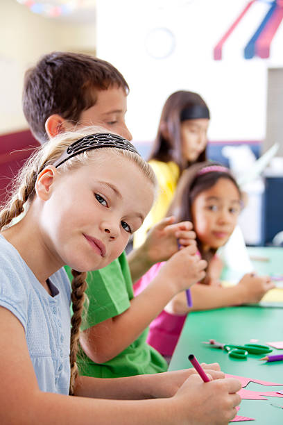 istock Group of elementary age children busy with arts project 154906570