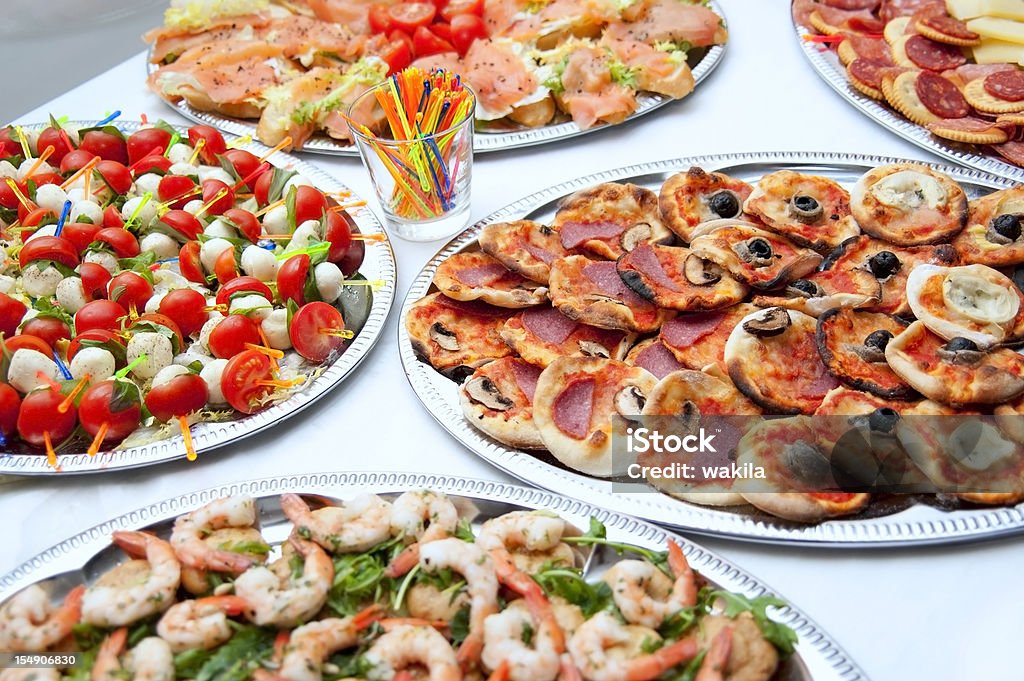 Somptueux buffet avec des tomates, des pizzas, du saumon et des crevettes - Photo de Buffet - Repas libre de droits