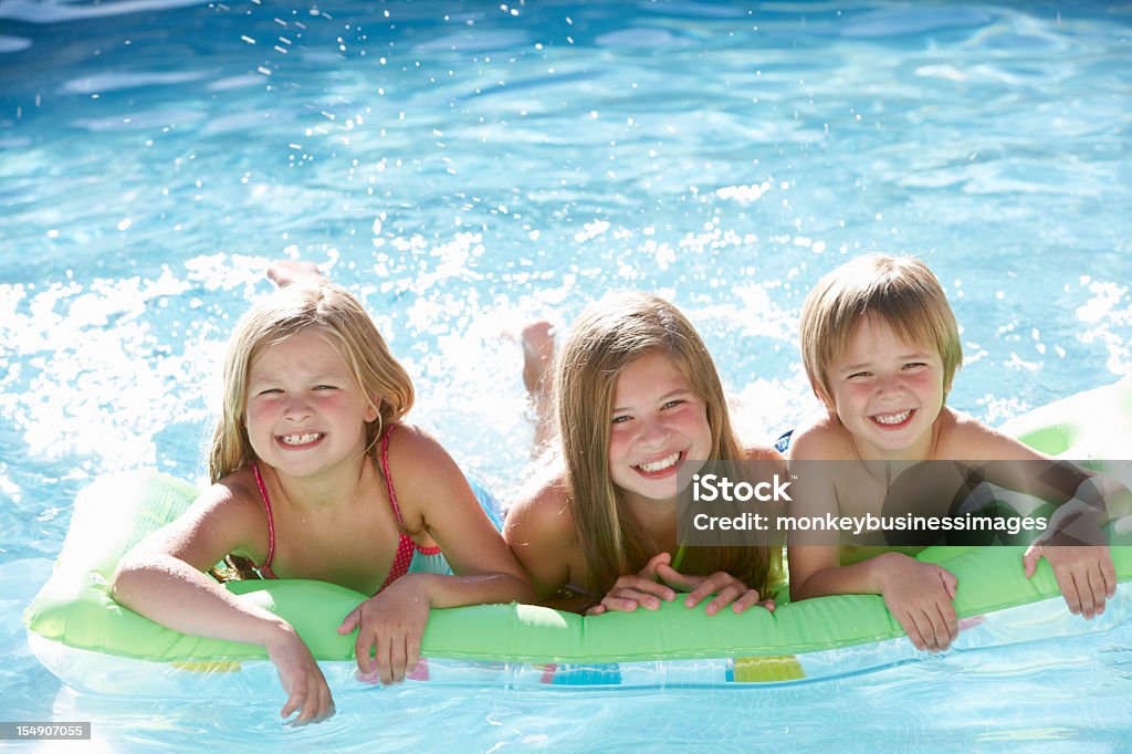 Gruppo di bambini, rilassante In piscina insieme - Foto stock royalty-free di Estate