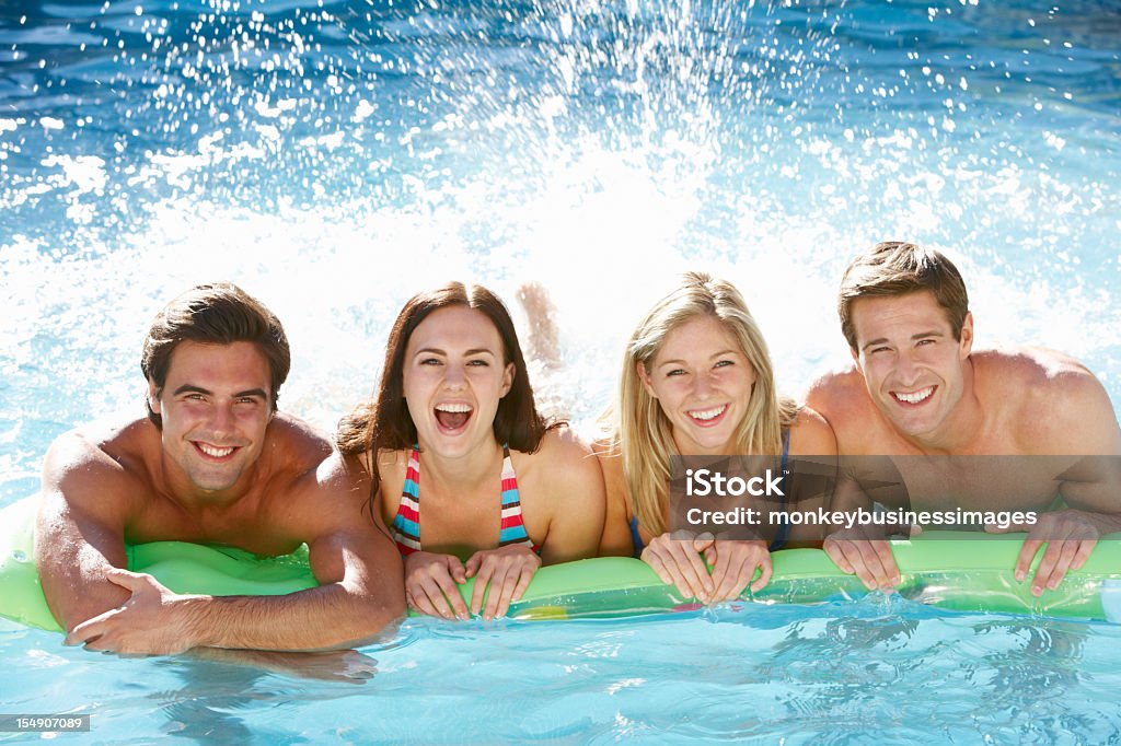Grupo de amigos se divertindo juntos na piscina - Foto de stock de 20 Anos royalty-free
