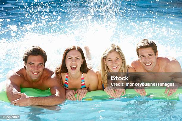 Foto de Grupo De Amigos Se Divertindo Juntos Na Piscina e mais fotos de stock de 20 Anos - 20 Anos, 30 Anos, Adulto