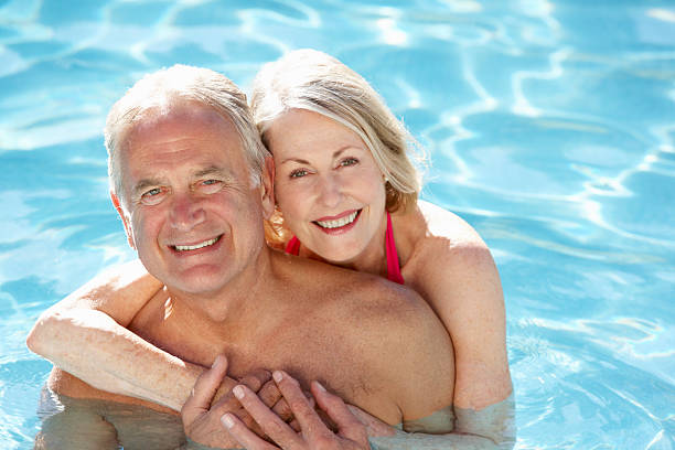 istock Senior couple embracing in a swimming pool 154907104