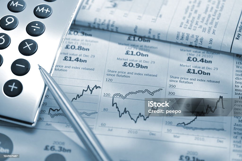 La calculadora de precios y lápiz de stock de gráficos de periódico financiero - Foto de stock de Ahorros libre de derechos