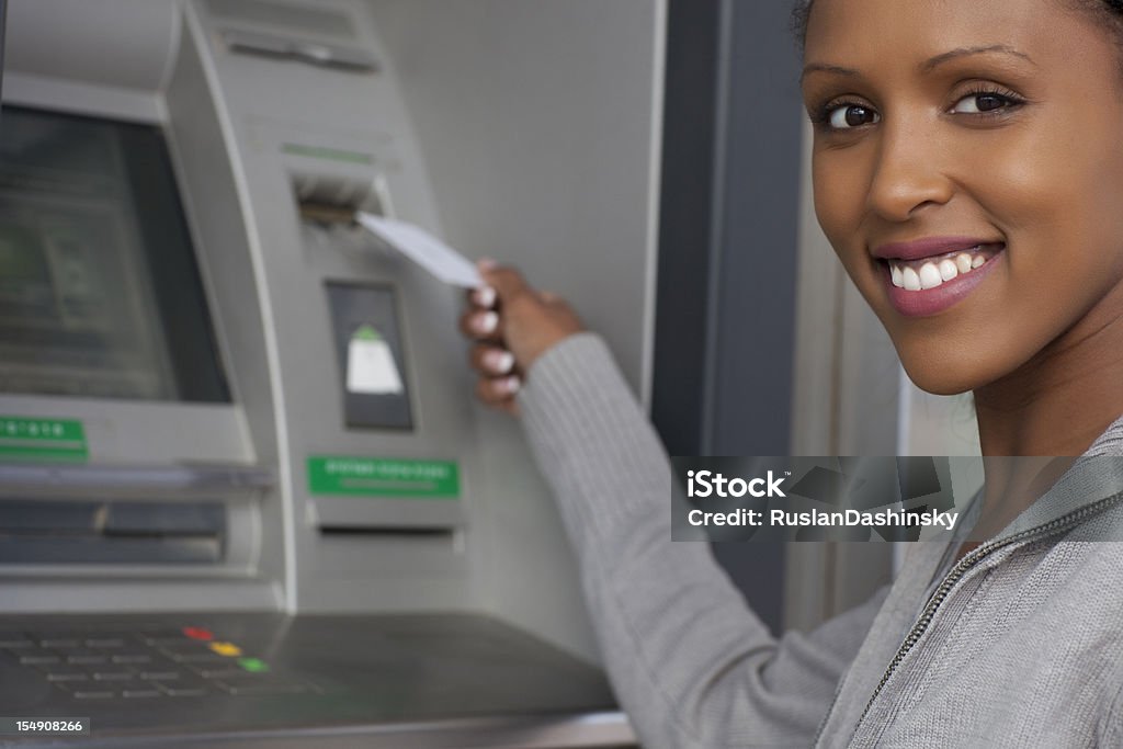 African przyzwoite kobieta wycofywanie pieniędzy z karty kredytowej w bankomacie. - Zbiór zdjęć royalty-free (20-24 lata)