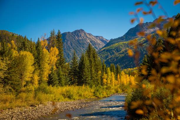 istock a river flows between a grassy area with mountains in the distance 1549083747
