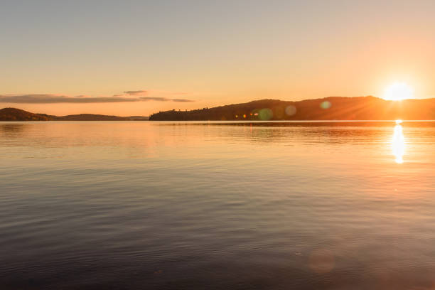 istock Sunset over a lake surrounded by forested hills in autumn. Tranquil scene. 1549112066
