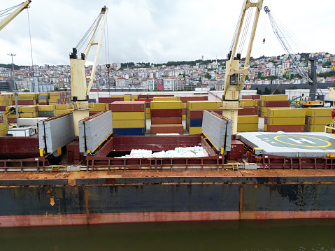 Cargo ship unloading from freight train in a commercial port.